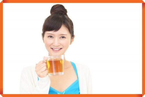 紅茶を持つ笑顔の女性